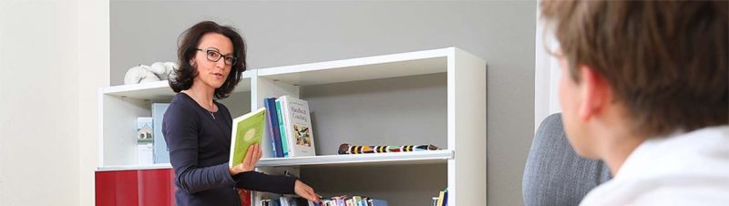 Dr. Steffi Arand und Bücherregal in den Räumen von Arand Coaching